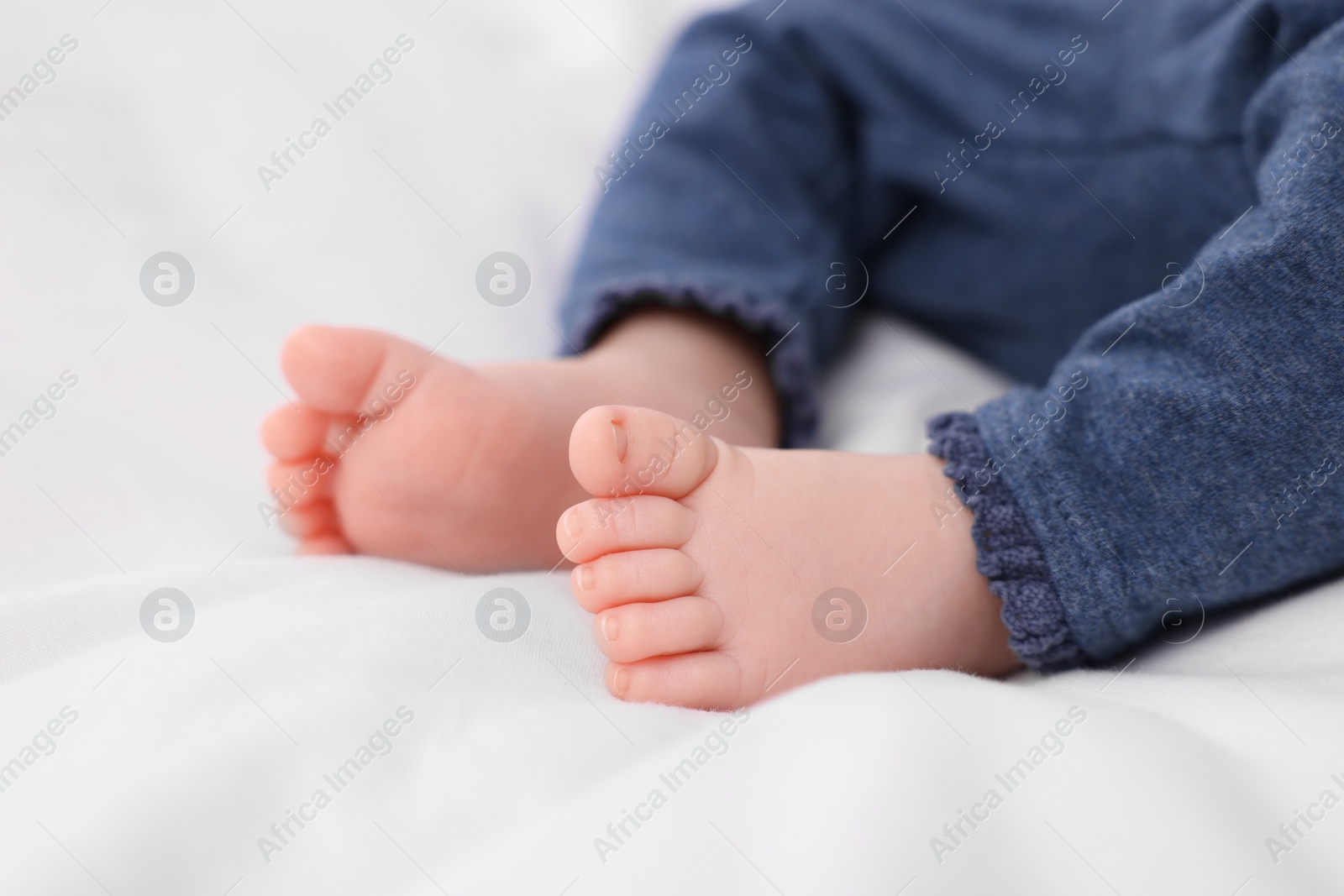 Photo of Newborn baby lying on white blanket, closeup