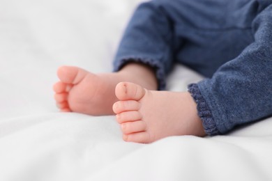 Newborn baby lying on white blanket, closeup