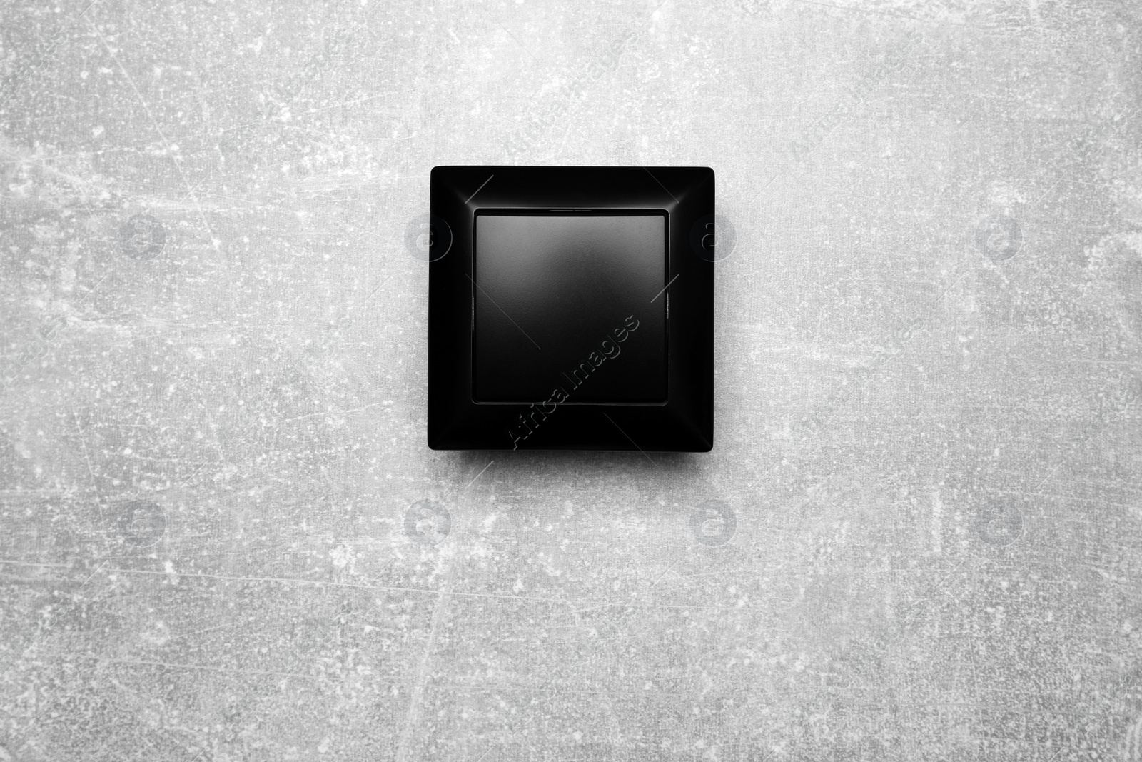 Photo of Black light switch on grey background, top view