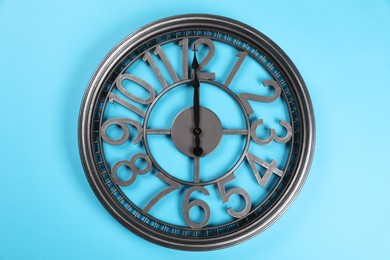 Photo of Stylish wall clock on turquoise background, top view