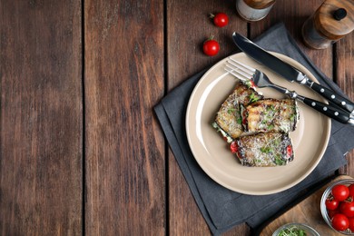 Delicious baked eggplant rolls served on wooden table, flat lay. Space for text