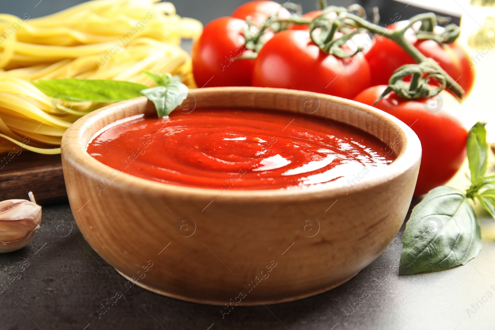 Photo of Bowl of tasty tomato sauce served on table, closeup