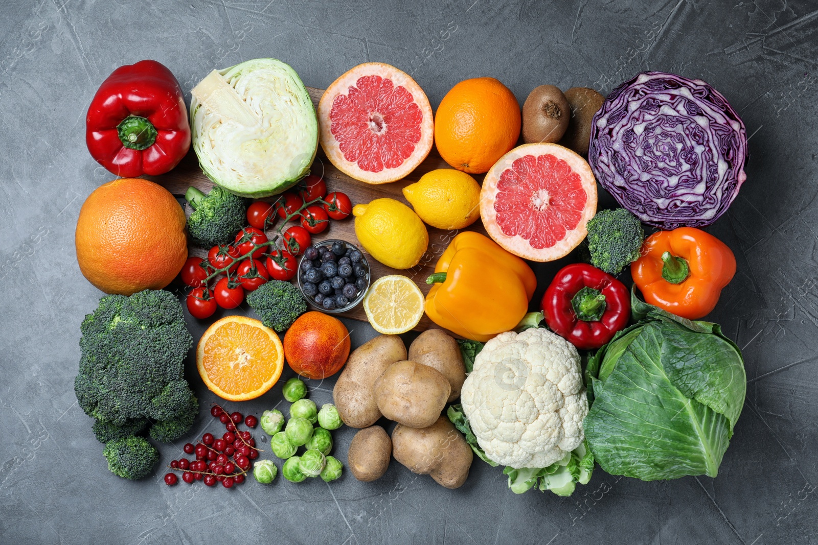 Photo of Different products rich in vitamin C on grey table, flat lay