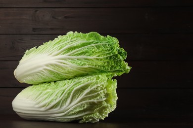 Photo of Fresh ripe Chinese cabbages on table against wooden background. Space for text