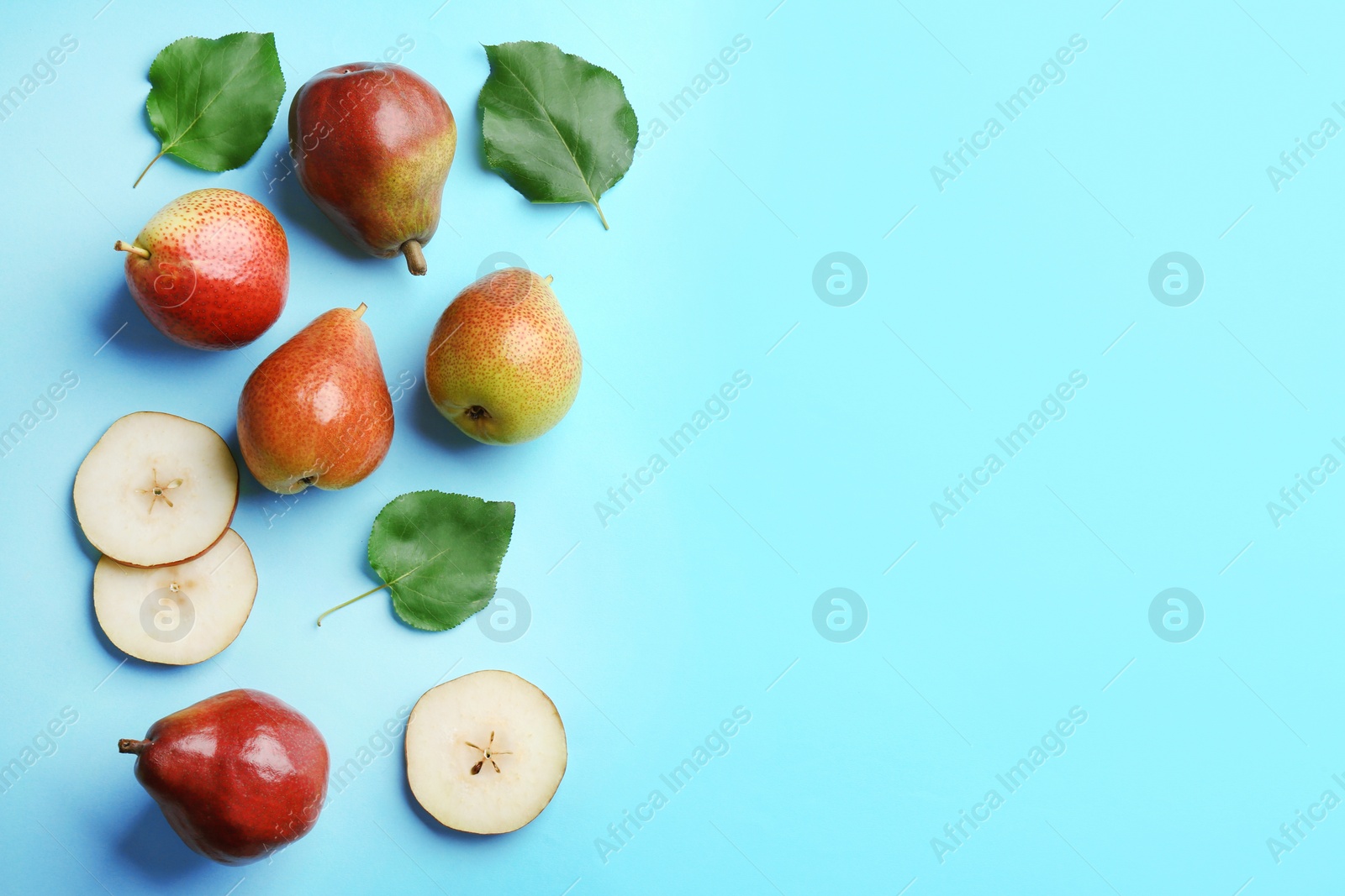 Photo of Ripe juicy pears on blue background, flat lay. Space for text