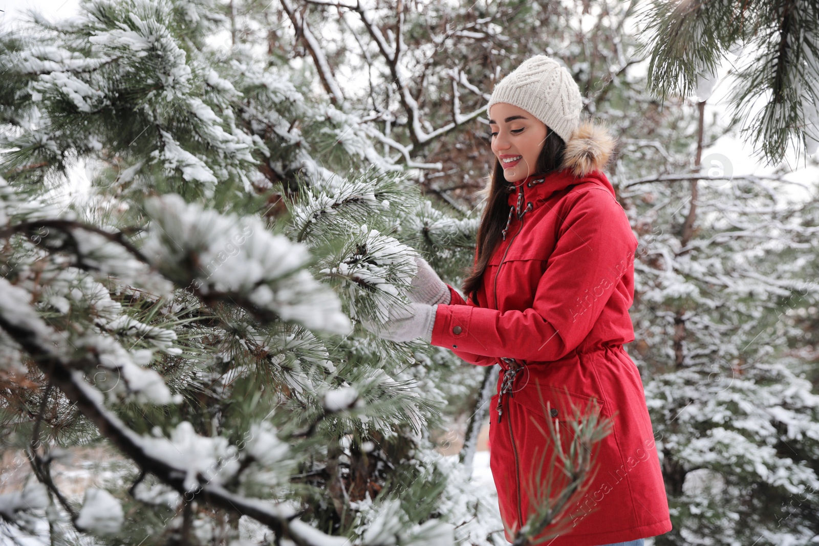 Photo of Happy young woman near tree in forest on winter day