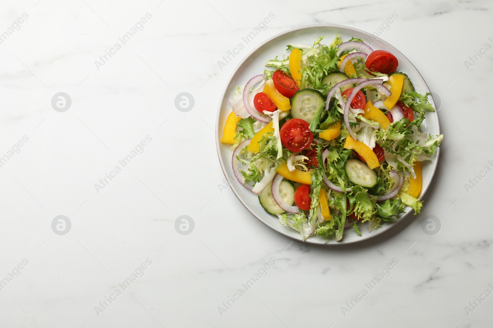 Photo of Tasty fresh vegetarian salad on white marble table, top view. Space for text