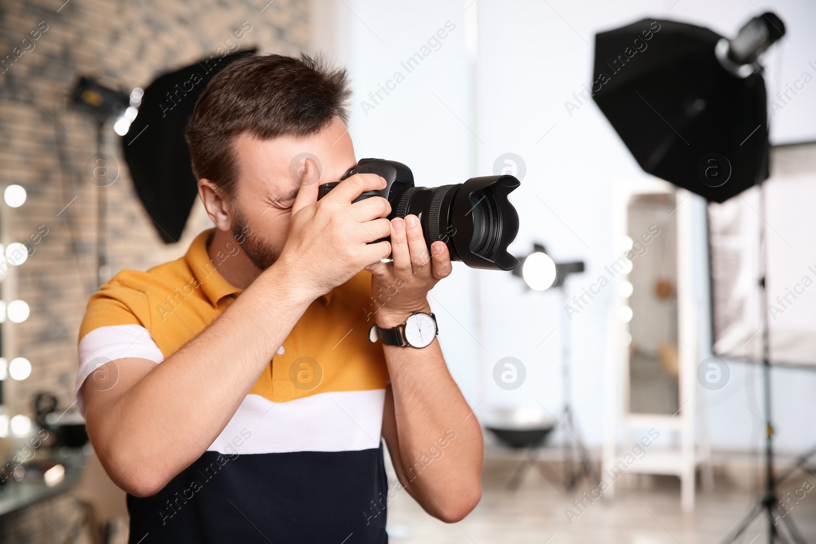 Photo of Professional photographer with camera in photo studio