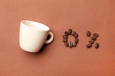 Photo of 0 percent made of coffee beans and cup on color background, flat lay. Decaffeinated drink