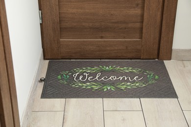 Photo of Beautiful doormat with word Welcome on floor near entrance