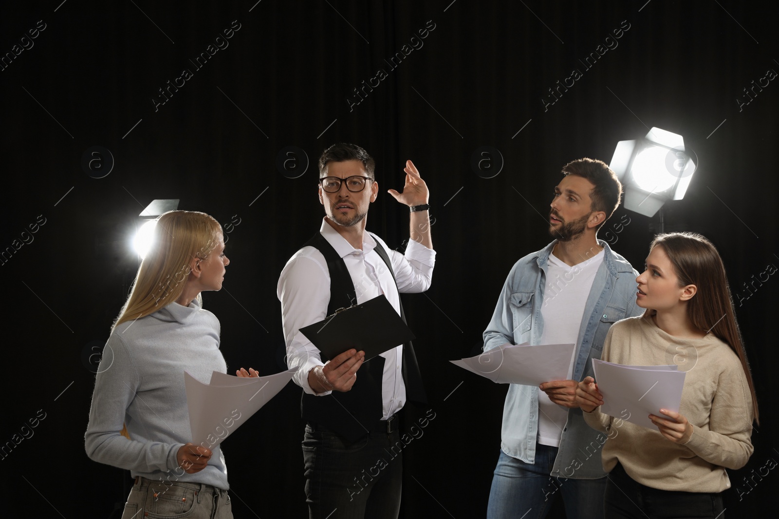 Photo of Professional actors reading their scripts during rehearsal in theatre