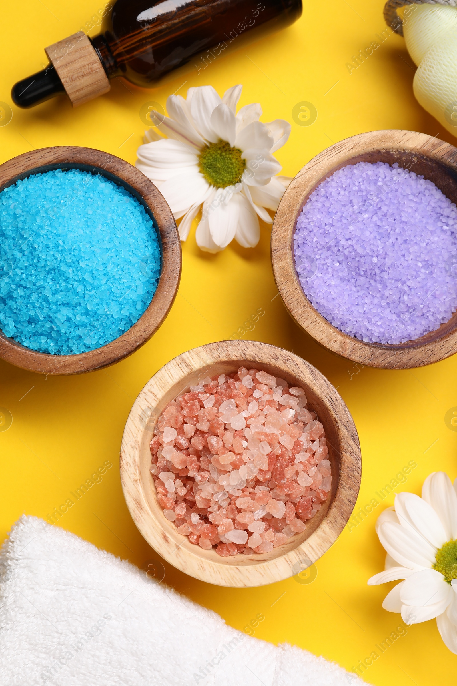 Photo of Flat lay composition with different sea salt on yellow background