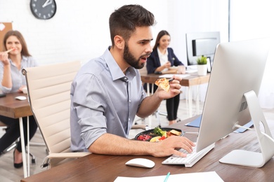 Photo of Office employees having lunch at workplace. Food delivery