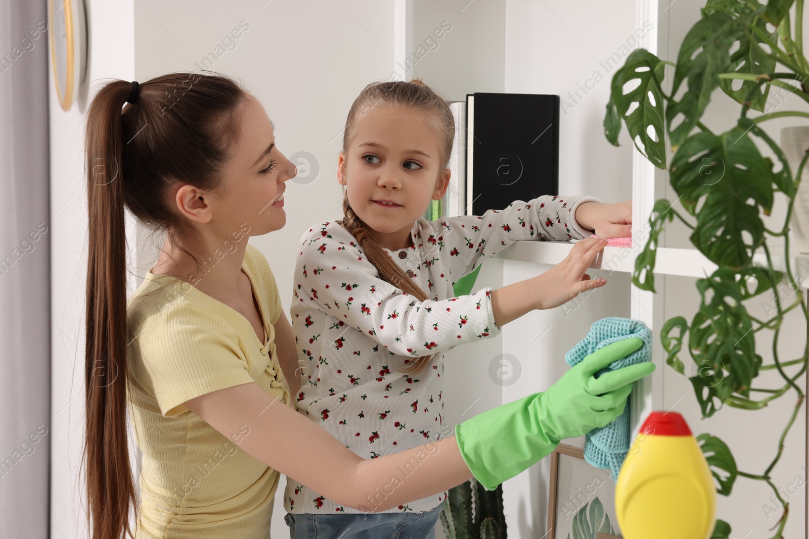 Photo of Spring cleaning. Mother and daughter tidying up together at home