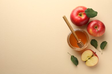 Delicious apples, jar of honey, leaves and dipper on beige background, flat lay. Space for text