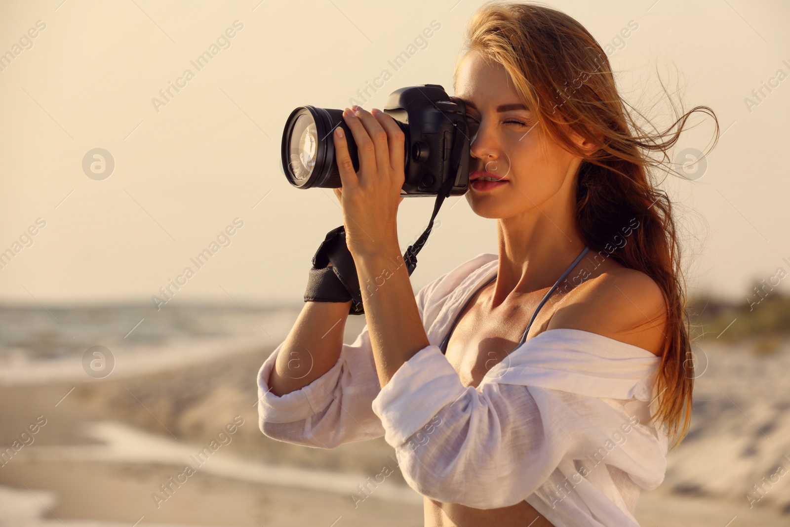 Photo of Photographer taking photo with professional camera near sea