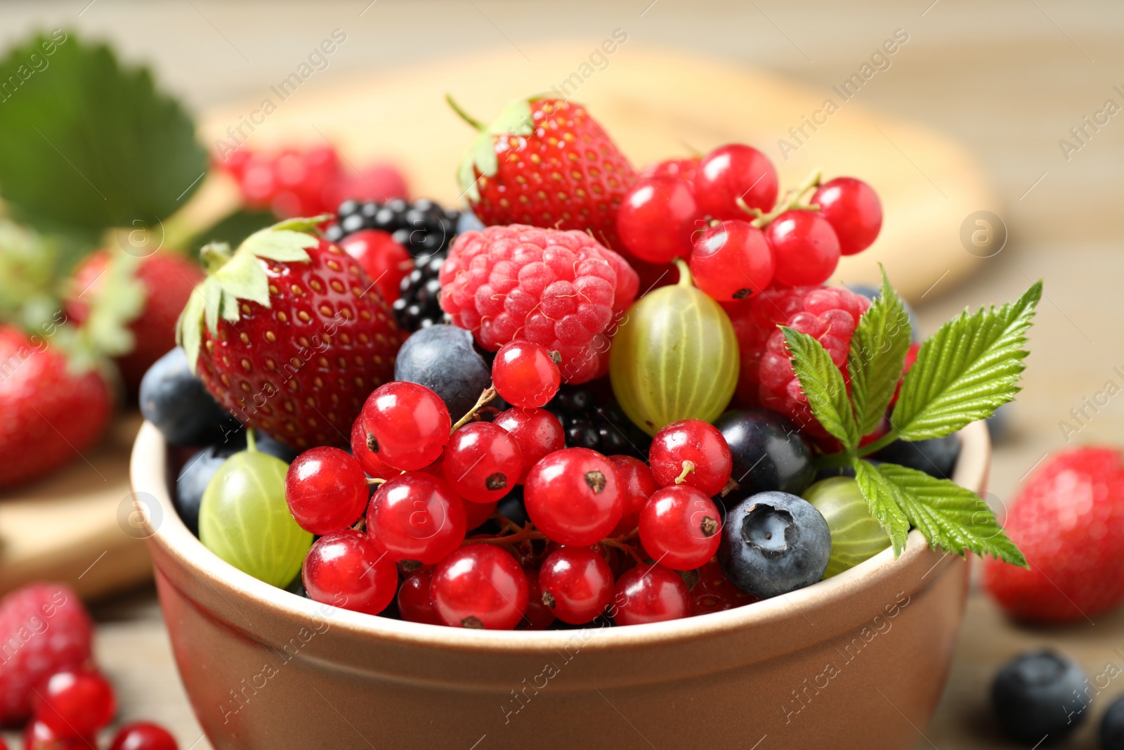 Photo of Mix of different fresh berries in bowl on table, closeup