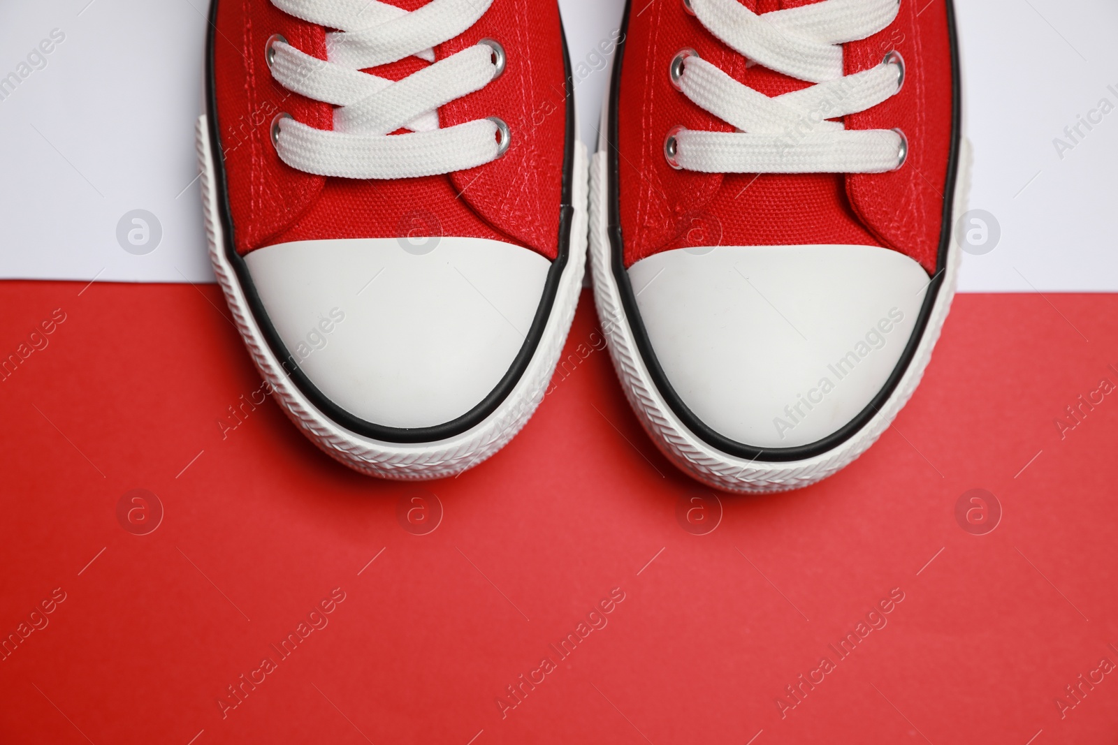 Photo of Pair of red classic old school sneakers on color background, flat lay