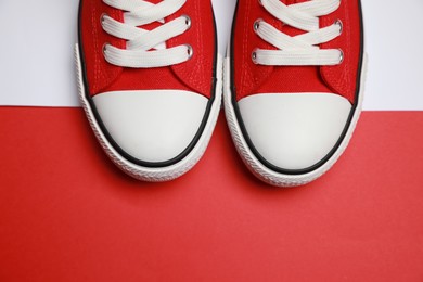 Pair of red classic old school sneakers on color background, flat lay