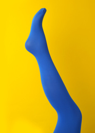Photo of Leg mannequin in blue tights on yellow background