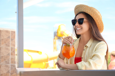 Photo of Woman with glass of refreshing drink outdoors. Space for text