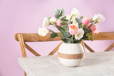 Photo of Vase with beautiful flowers as element of interior design on table in room