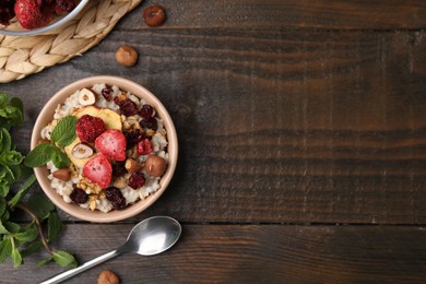 Photo of Oatmeal with freeze dried fruits, nuts and mint on wooden table, flat lay. Space for text