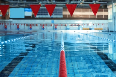 Photo of Modern swimming pool with blue water, indoors