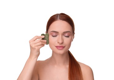 Young woman massaging her face with jade gua sha tool isolated on white