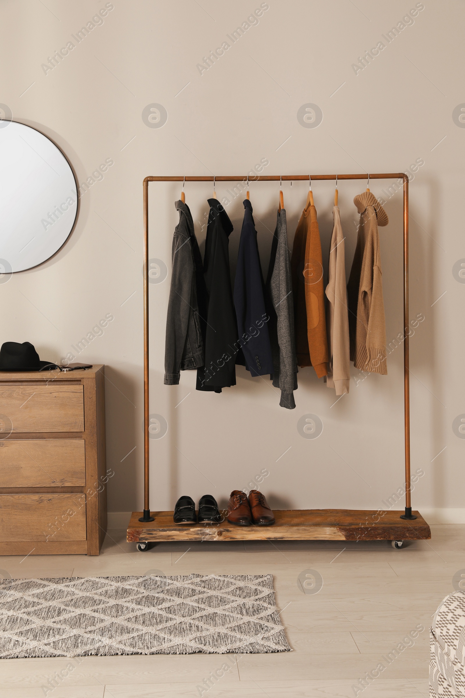 Photo of Modern dressing room interior with stylish clothes, shoes and mirror