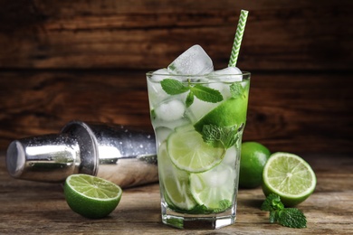 Photo of Delicious mojito and ingredients on wooden table