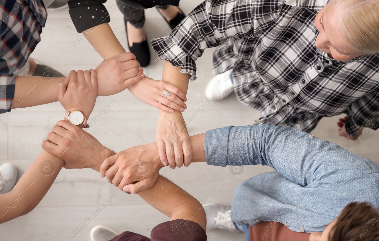 Photo of People holding hands together, top view. Unity concept