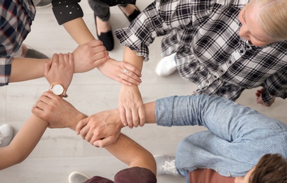Photo of People holding hands together, top view. Unity concept