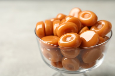 Photo of Dessert bowl filled with tasty candies on light table, closeup