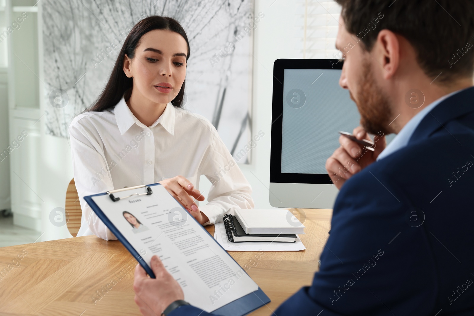 Photo of Human resources manager reading applicant's resume in office