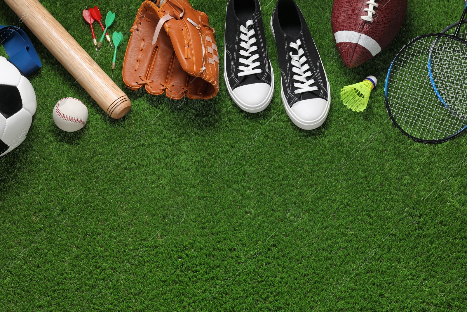 Photo of Different sport tools on green grass, flat lay. Space for text