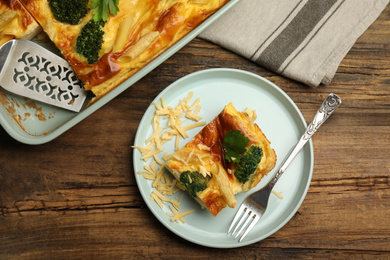 Photo of Tasty broccoli casserole served on wooden table, flat lay