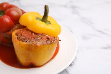 Photo of Delicious stuffed bell peppers served on white marble table, closeup. Space for text