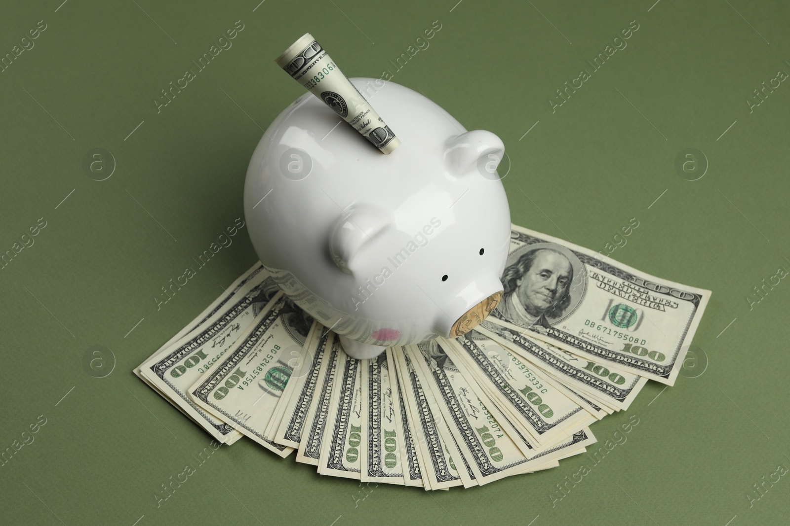 Photo of Money exchange. Dollar banknotes and piggy bank on green background