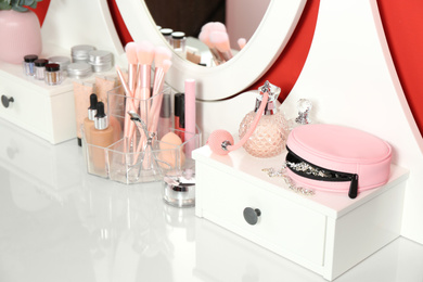 Dressing table with mirror and makeup products, closeup