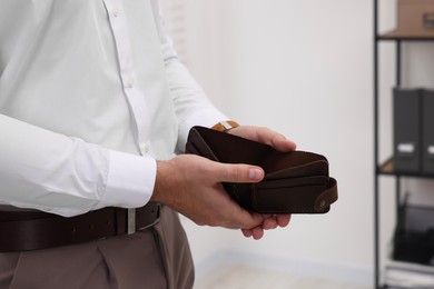 Man with empty wallet in office, closeup