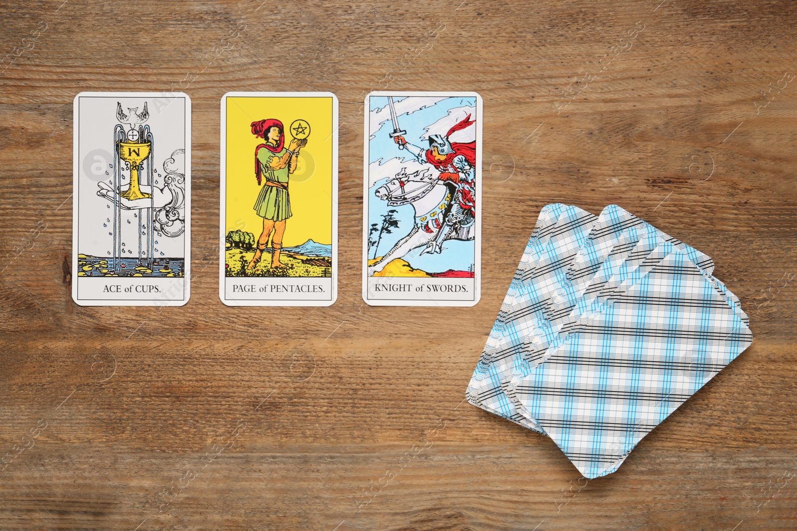 Photo of Tarot cards on wooden table, flat lay