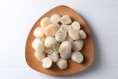 Photo of Fresh raw scallops and thyme on white wooden table, top view