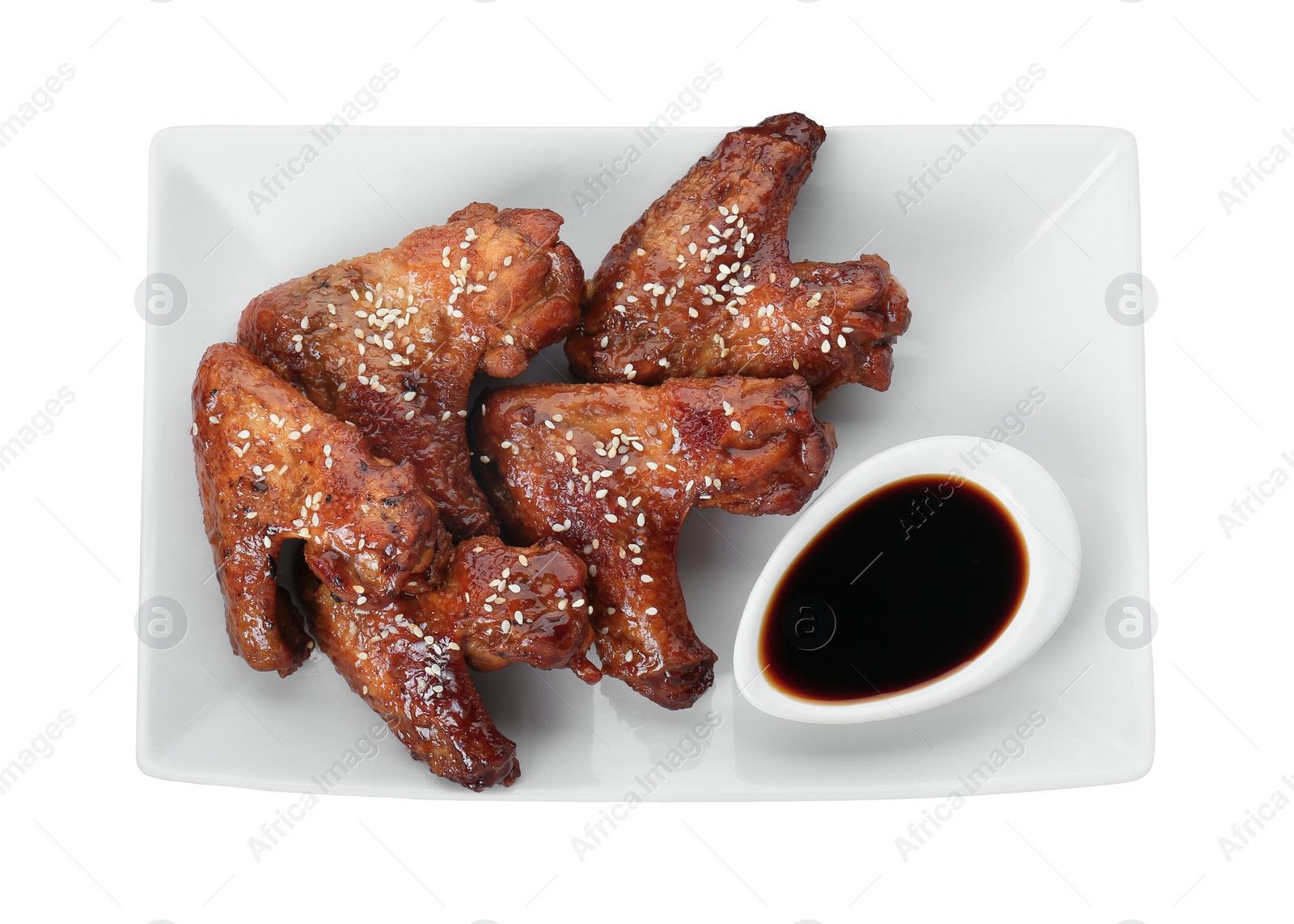 Photo of Glazed chicken wings and soy sauce isolated on white, top view