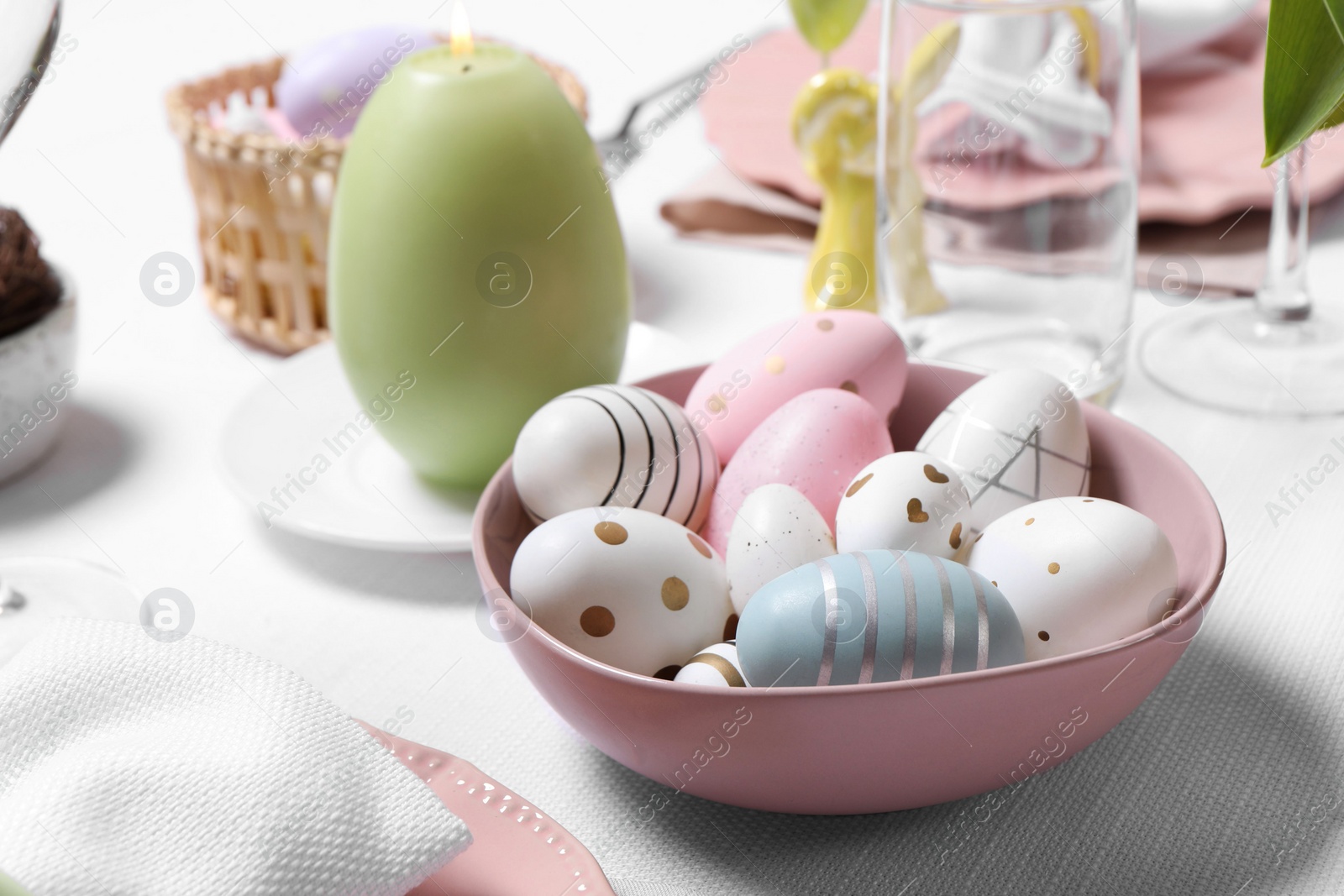 Photo of Festive table setting with painted eggs, closeup. Easter celebration