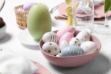 Festive table setting with painted eggs, closeup. Easter celebration
