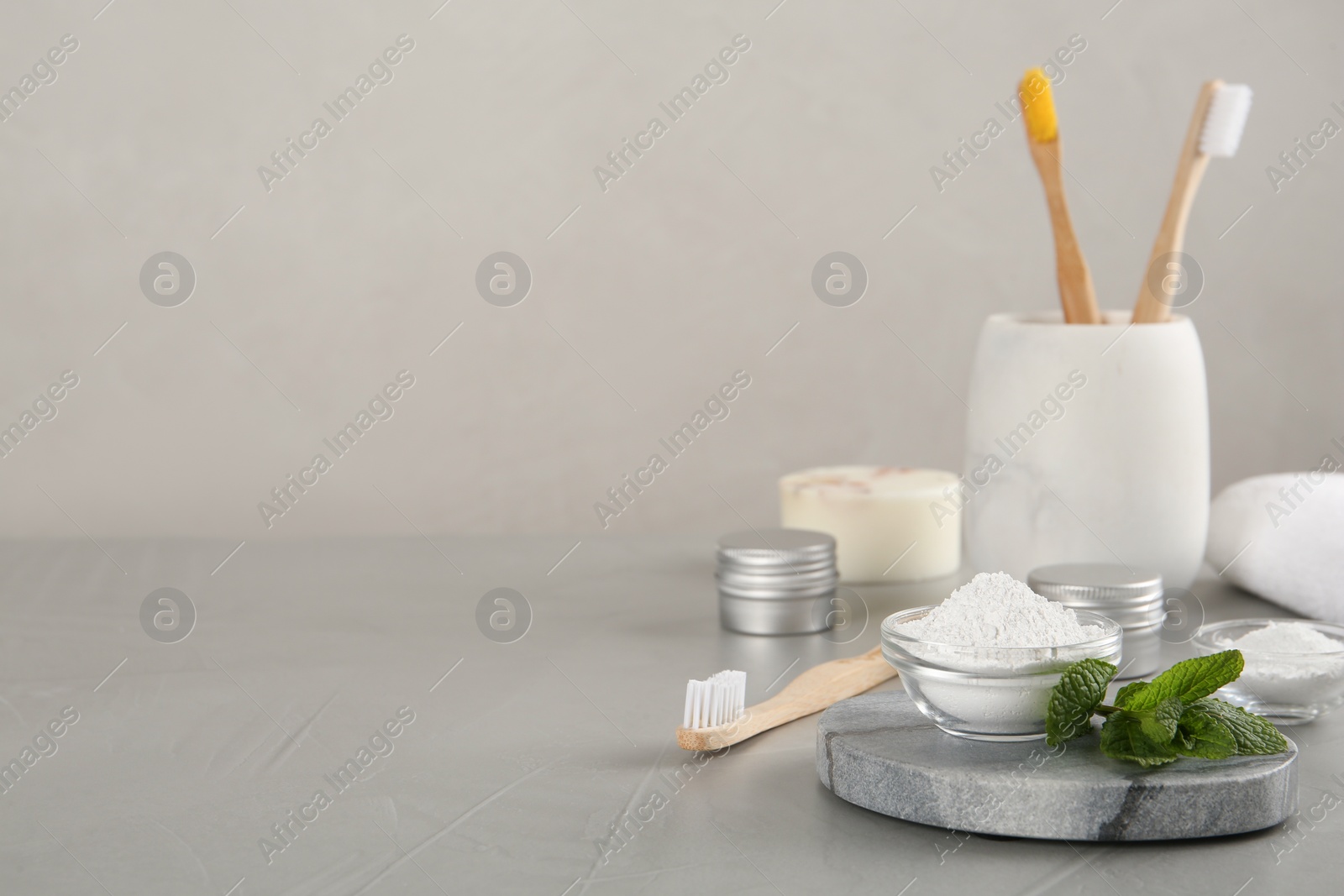 Photo of Composition with tooth powder and mint on grey table, space for text