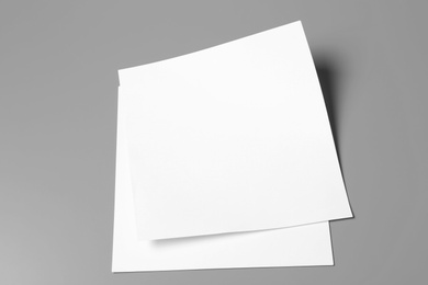 Photo of Blank paper sheets for brochure on grey background. Mock up