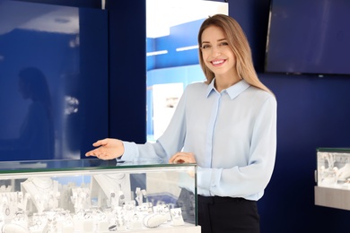 Portrait of young saleswoman near showcase in jewelry store