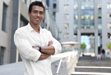 Handsome young African-American man on city street. Space for text